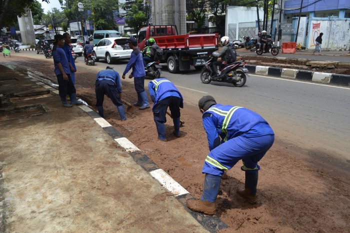 Petugas Gabungan Bersihkan Sisa Banjir Jalanan